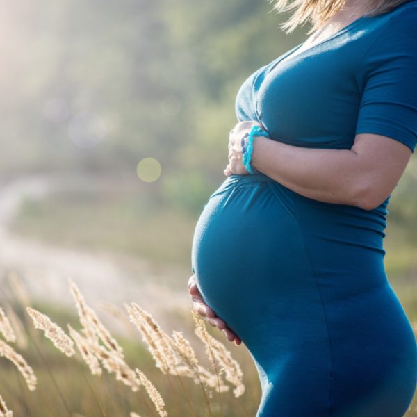 Blonde pregnant woman outdoors at the sunset
