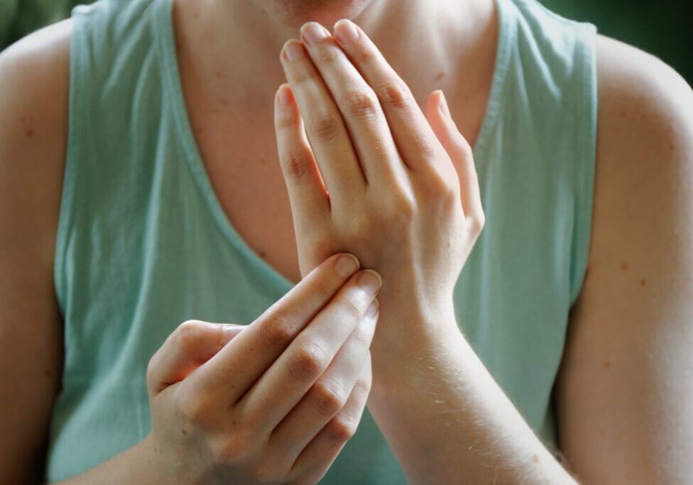 Person practicing EFT. Female tapping gamut point, hands close-up view.